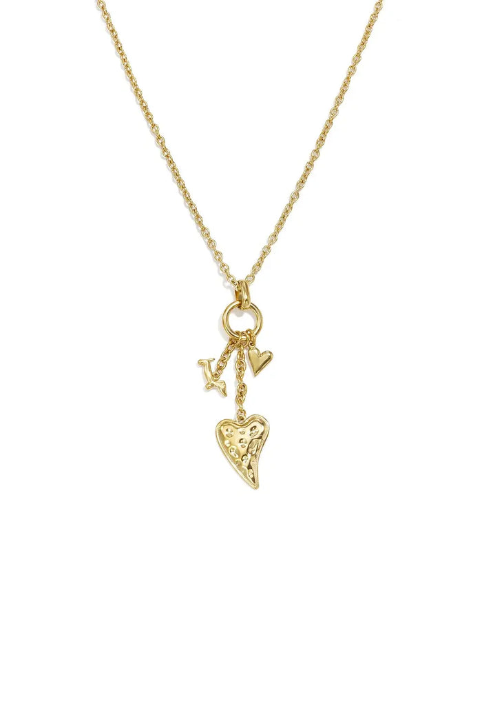A gold-plated stainless steel necklace featuring a cluster of three charms including a large hammered heart, a smooth puffed heart, and a mini charm on a delicate chain against a white background. amara-multi-charm-cluster-heart-necklace.webp