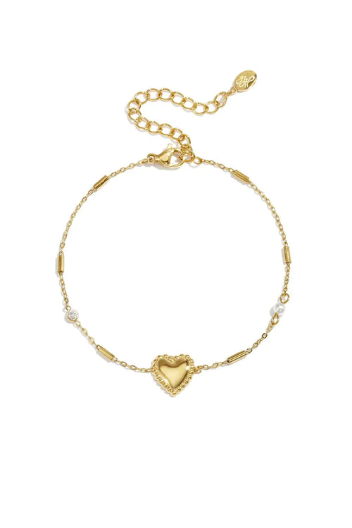 A gold-plated stainless steel chain station bracelet featuring a central beaded-border heart, cylindrical bar links, a small clear cubic zirconia stone, and a tiny pearl accent. adore-beaded-heart-station-bracelet.webp