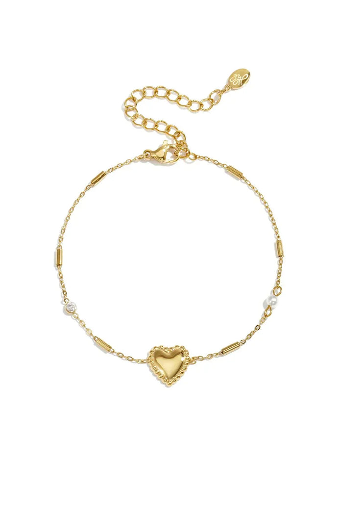 A gold-plated stainless steel chain station bracelet featuring a central beaded-border heart, cylindrical bar links, a small clear cubic zirconia stone, and a tiny pearl accent. adore-beaded-heart-station-bracelet.webp