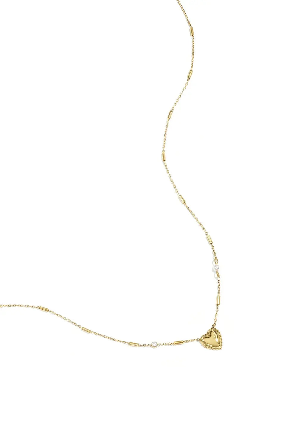 A gold-plated stainless steel chain necklace featuring a central beaded-border heart pendant, cylindrical bar links, a small clear cubic zirconia stone, and a tiny pearl accent. adore-beaded-heart-station-necklace.webp