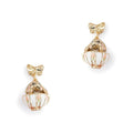 A pair of Bill Skinner gold drop earrings featuring a structured gold bow stud suspending a miniature white enamel teacup with a gold bunny inside.