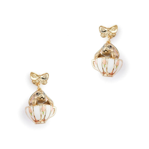 A pair of Bill Skinner gold drop earrings featuring a structured gold bow stud suspending a miniature white enamel teacup with a gold bunny inside.