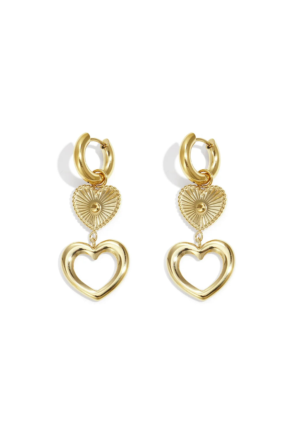 A pair of gold-plated stainless steel huggie hoop earrings featuring a cascading drop of a sunburst heart medallion and a larger open-heart charm against a white background. amour-tiered-sunburst-open-heart-drop-huggie-earrings.webp