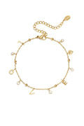 A delicate gold-plated stainless steel chain bracelet spelling out the word LOVE with dangling letter charms, alternating with bezel-set round clear crystals and a small gold heart charm. amour-epeler-love-charm-bracelet.webp