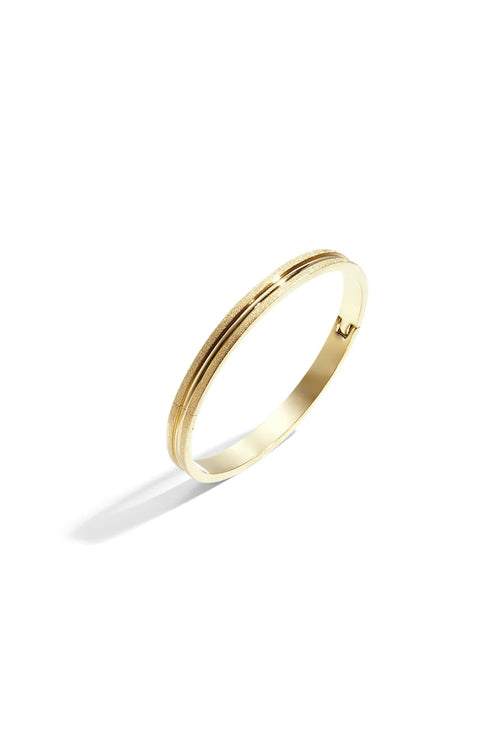 A gold-plated stainless steel oval hinged bangle featuring a frosted brushed-satin texture on the outer bands and a recessed center groove against a white background. aurelia-brushed-dual-texture-gold-bangle.webp