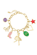 A gold-plated stainless steel charm bracelet featuring a cable link chain decorated with charms including a ballerina, a pink cowgirl boot, a ribbon bow, a purple swirl disc, a red starfish, an open heart outline, and a green script oval. ballerina-dream-charm-bracelet.jpg
