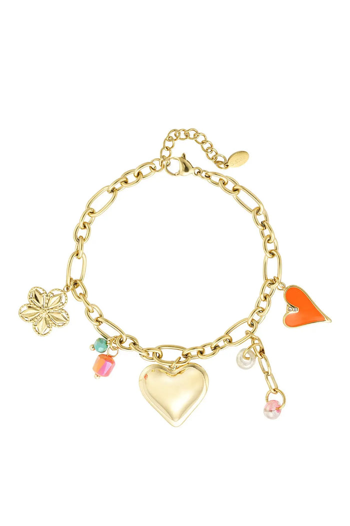 A chunky gold-plated stainless steel cable chain charm bracelet featuring an oversized puffy gold heart, a filigree flower charm, an orange enamel heart, a small pearl ring, and pink and green accent beads against a white background. capri-chunky-eclectic-charm-link-bracelet.webp