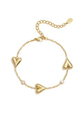 A delicate gold-plated stainless steel chain bracelet featuring three stationed 3D puffy heart charms alternating with two round bezel-set clear crystals. cherie-station-heart-bracelet.webp