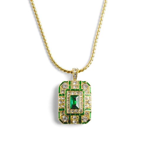 An ornate 14ct gold-plated Art Deco pendant necklace featuring a rectangular emerald crystal centered on a geometric shield with green enamel and clear crystals.