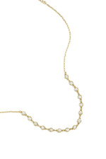 A gold-plated stainless steel necklace featuring a central arc of round cubic zirconia crystal stations connected to a fine link chain against a white background. clara-crystal-station-necklace.webp