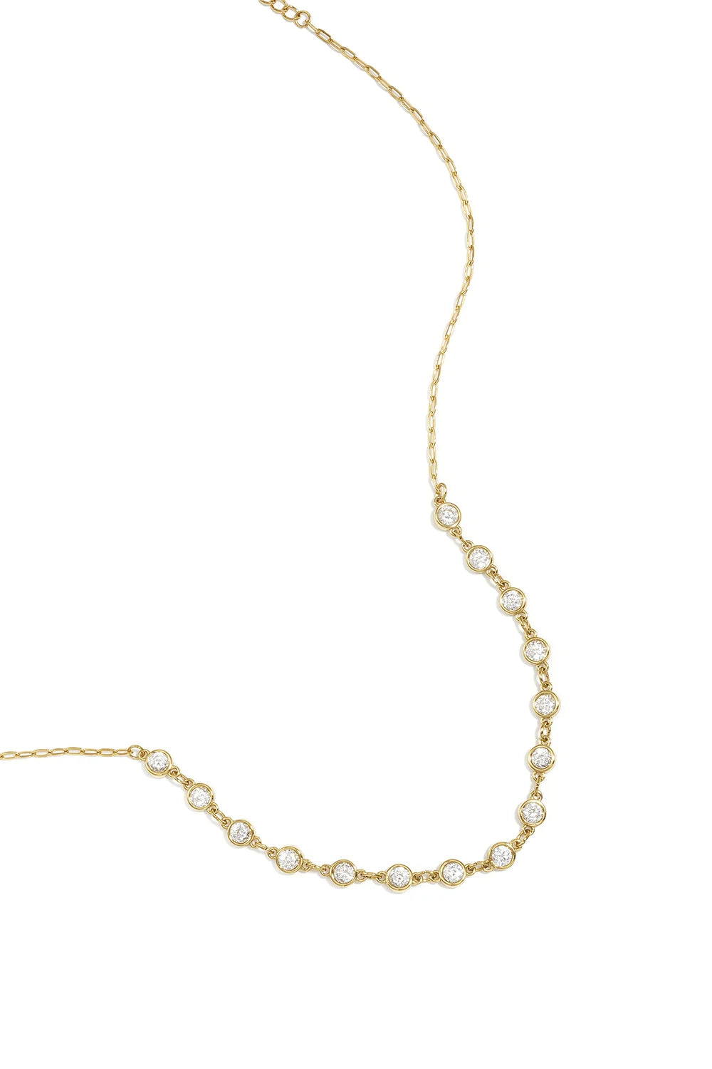 A gold-plated stainless steel necklace featuring a central arc of round cubic zirconia crystal stations connected to a fine link chain against a white background. clara-crystal-station-necklace.webp