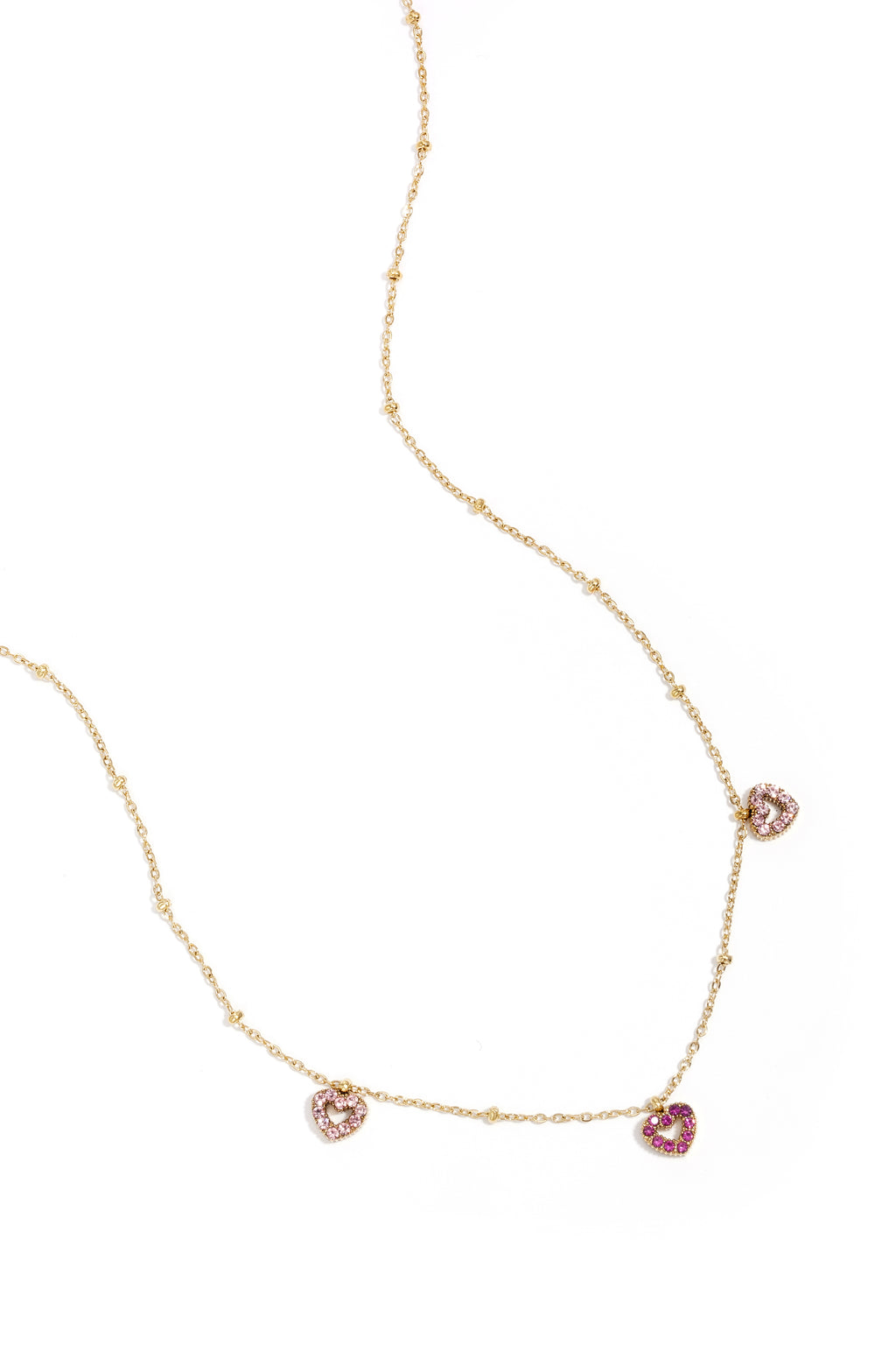 A delicate gold-plated satellite chain necklace featuring three open-heart charm stations encrusted with soft pink and rich magenta pavé crystals. colette-multi-heart-necklace.jpg