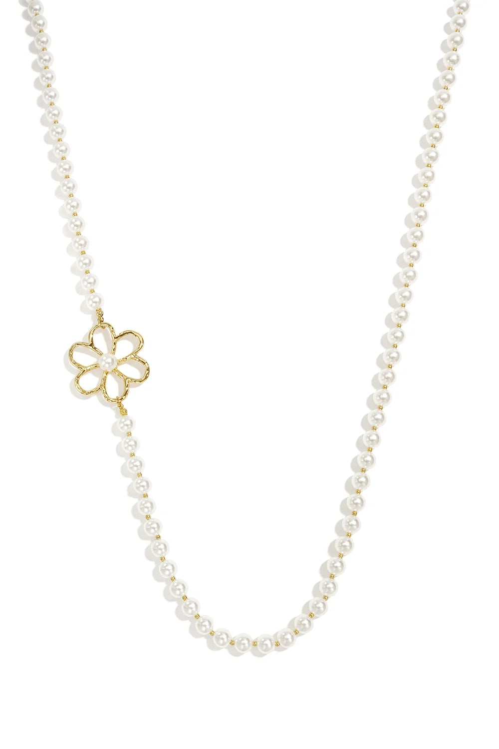 A strand necklace made of white glass pearls with an asymmetrical openwork gold flower charm featuring a center pearl against a white background. evangeline-asymmetric-floral-pearl-necklace.webp