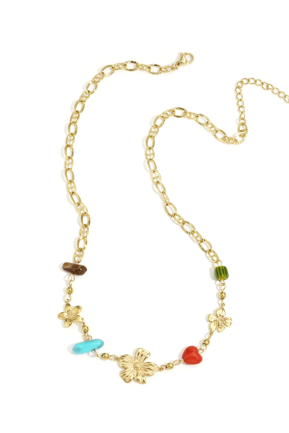 A gold-plated stainless steel necklace featuring textured gold flower charms paired with turquoise, red heart, green, and brown stone beads on a diamond-cut link chain against a white background. fiore-multi-gem-textured-flower-necklace.webp