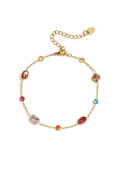 A delicate gold-plated stainless steel chain bracelet featuring various shapes of colourful cubic zirconia gemstone stations against a white background. iris-multi-gemstone-station-bracelet.webp