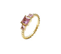 A gold-plated ring featuring a textured beaded bobble band set with a central square-cut pink crystal solitaire flanked by two small pink baguette crystals. juliet-pink-crystal-ring.webp