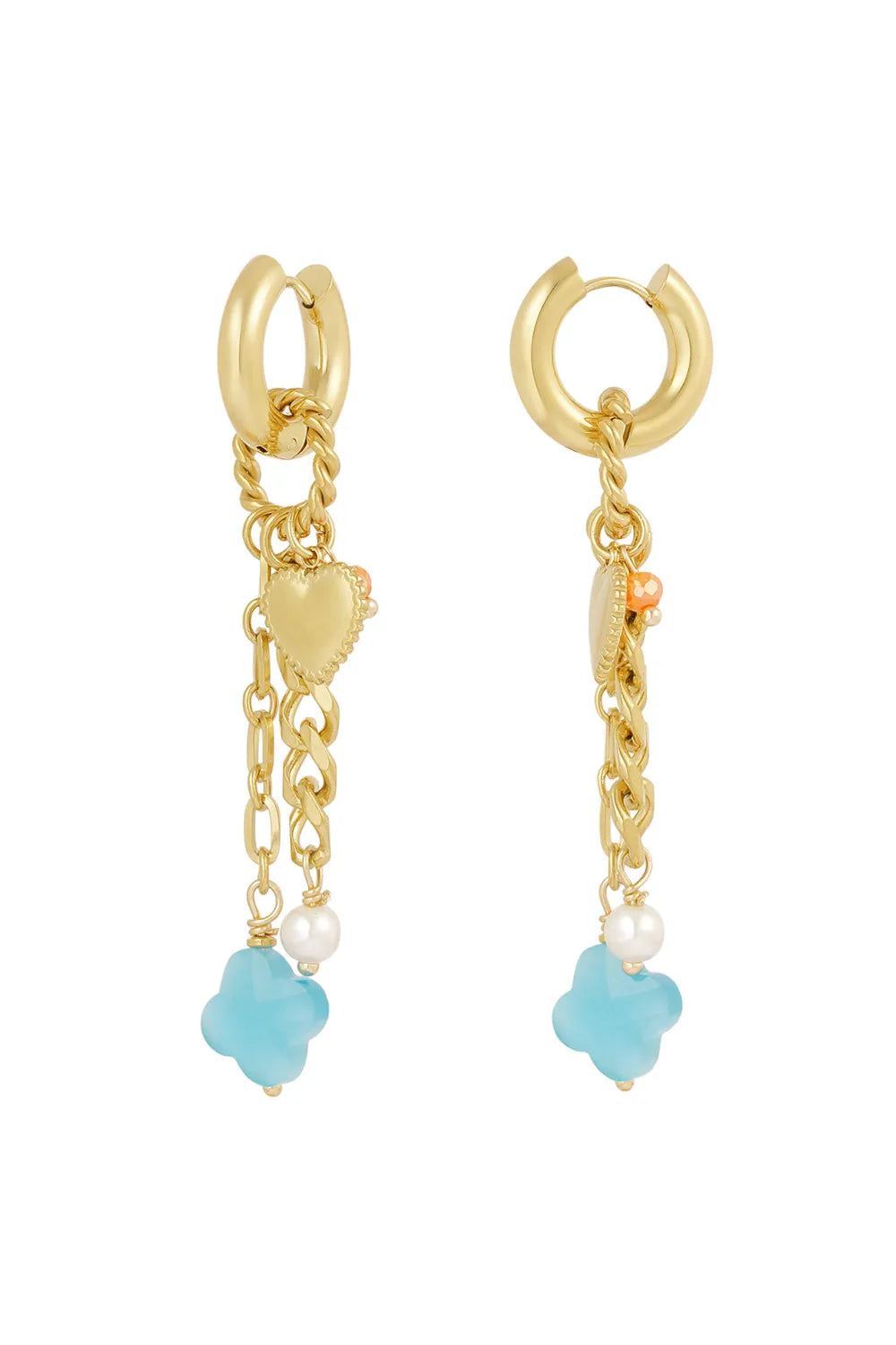 A pair of gold-plated huggie hoop earrings featuring cascading chains decorated with a scalloped gold heart charm, a white pearl bead, a small coral bead, and a dangling translucent sky-blue clover. laguna-charm-cascade-earrings.webp