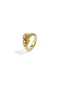 A chunky gold-plated stainless steel statement ring featuring a central textured love knot design with ribbed vertical grooves on the band. lovers-knot-ribbed-statement-ring.webp
