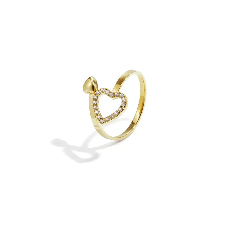 A gold-plated stainless steel bypass ring featuring a wrap-around band adorned with an open pavé crystal heart and a small 3D puffy gold heart. mimi-heart-bypass-ring.webp