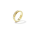 A gold-plated stainless steel domed band ring featuring three small inset clear crystals across the front against a plain white background. nora-three-stone-domed-ring.webp