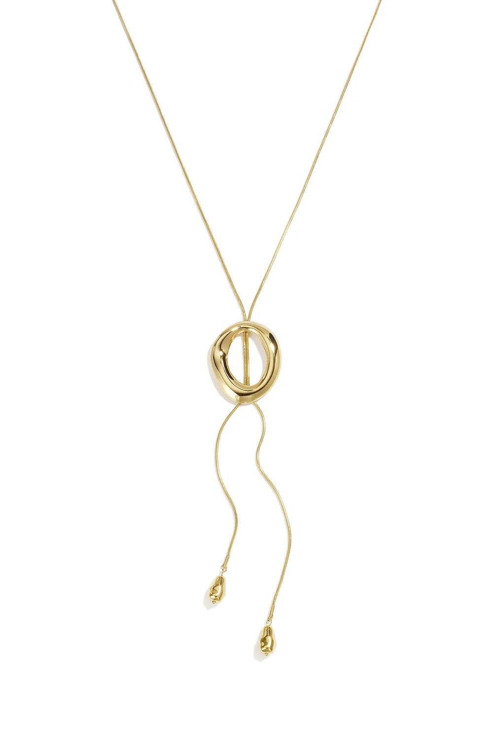 A gold-plated stainless steel lariat necklace featuring a fluid snake chain passing through a sculpted molten oval ring with two cascading chain ends finished with organic teardrop beads against a white background. paloma-molten-ring-lariat-teardrop-necklace.webp