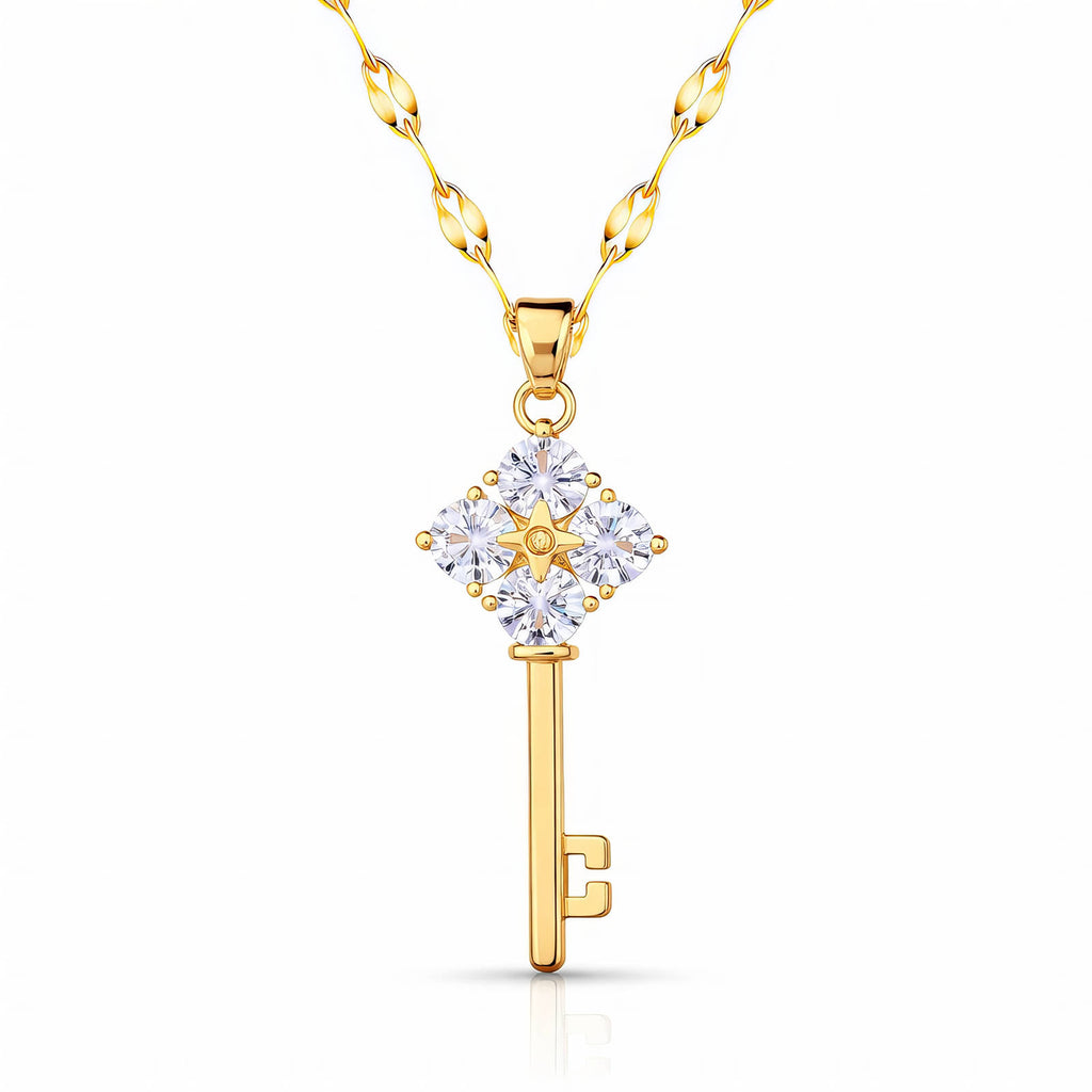 A gold skeleton key pendant necklace with four large clear crystals on the handle, hanging from a gold petal-link chain on a white background.