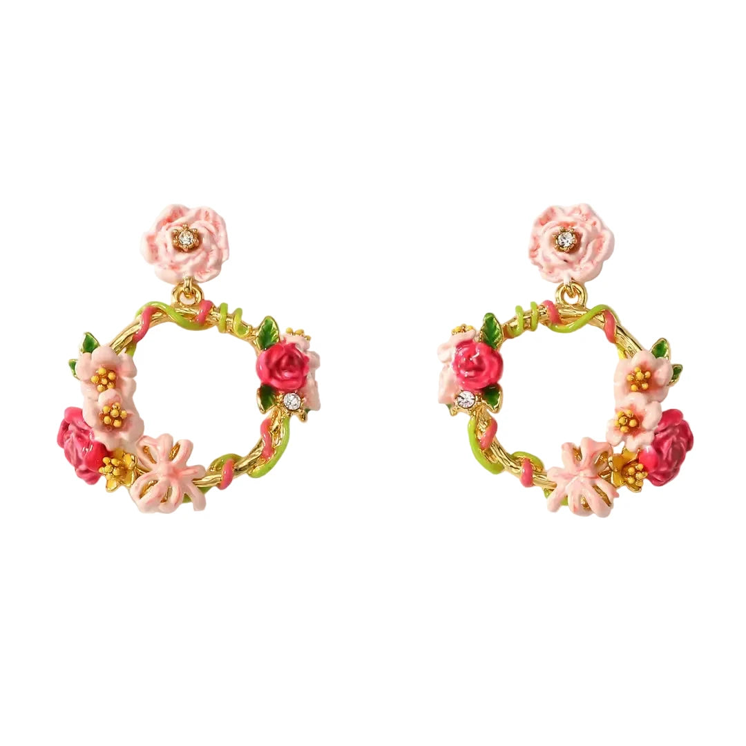 A pair of gold-plated wreath drop earrings by Verdivine featuring intricate hand-painted enamel pink and magenta flowers, green vines, and tiny clear crystal accents. verdivine-flower-wreath-earrings.webp