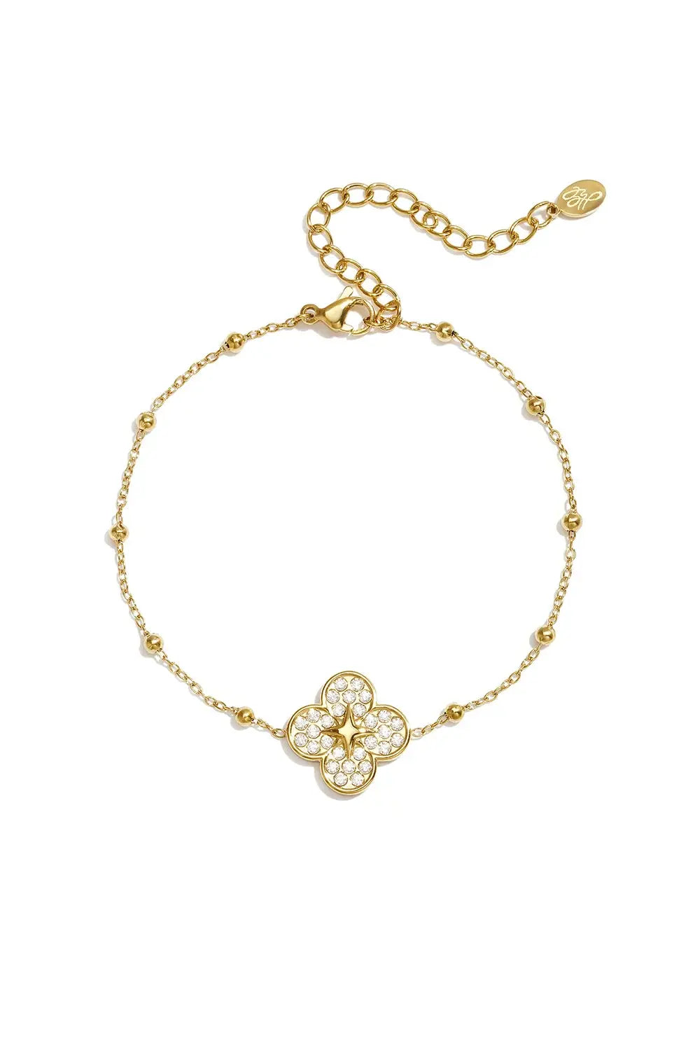 A gold-plated stainless steel satellite chain bracelet featuring a four-leaf clover charm encrusted with pave cubic zirconia and a central golden starburst motif against a white background. seraphina-pave-clover-starburst-satellite-bracelet.webp