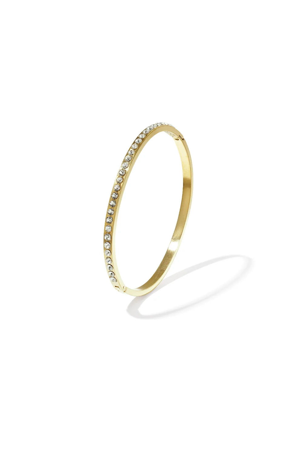 A gold-plated stainless steel hinged bangle featuring a continuous row of flush-set clear cubic zirconia crystals against a white background. serena-pave-crystal-gold-bangle.webp