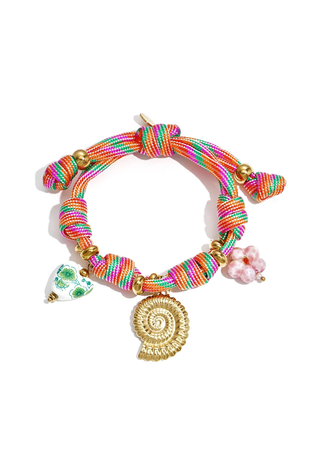 Close-up of a colourful orange, pink, and green woven rope bracelet with a gold spiral shell charm, a pink glass flower, and a green floral ceramic heart bead.