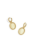 A pair of gold-plated stainless steel huggie hoop earrings featuring a dangling oval medallion coin with a detailed rope-textured border and a delicate engraved tulip flower sprig against a white background. tulipa-oval-floral-coin-huggie-earrings.webp