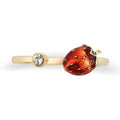 A gold-plated open bypass ring by Bill Skinner featuring a realistic 3D strawberry hand-painted with glossy red enamel and gold seeds, balanced by a bezel-set clear crystal. strawberry-enamel-ring.webp