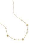 A delicate gold-plated chain necklace featuring alternating stations of small high-polish puffed stars, bezel-set clear crystals, and tiny gold satellite beads. etoile-star-crystal-station-necklace.webp