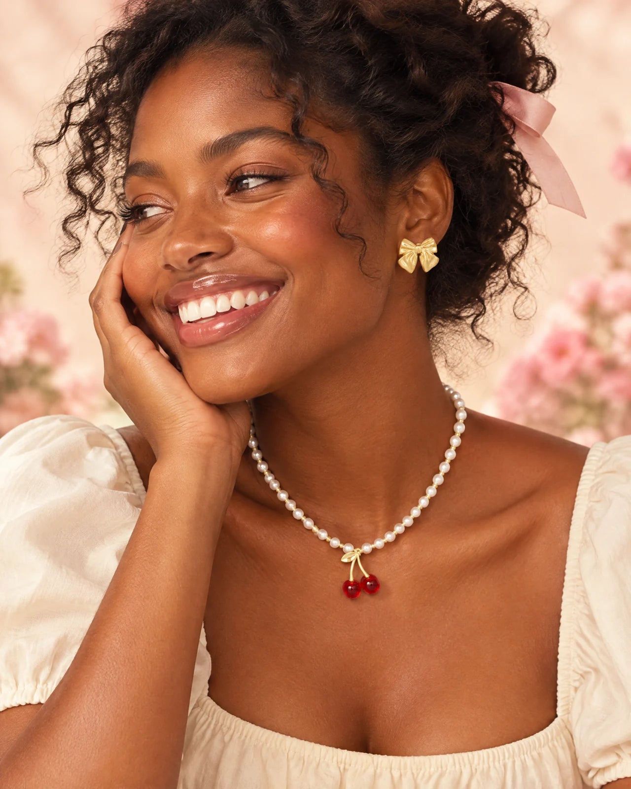 AI-created adult model styling Mignon gold bow earrings and the Cerise cherry pearl necklace
